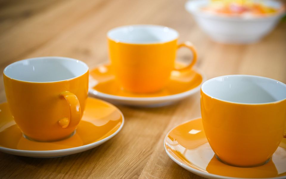 Orangene Tassen auf einem Holztisch